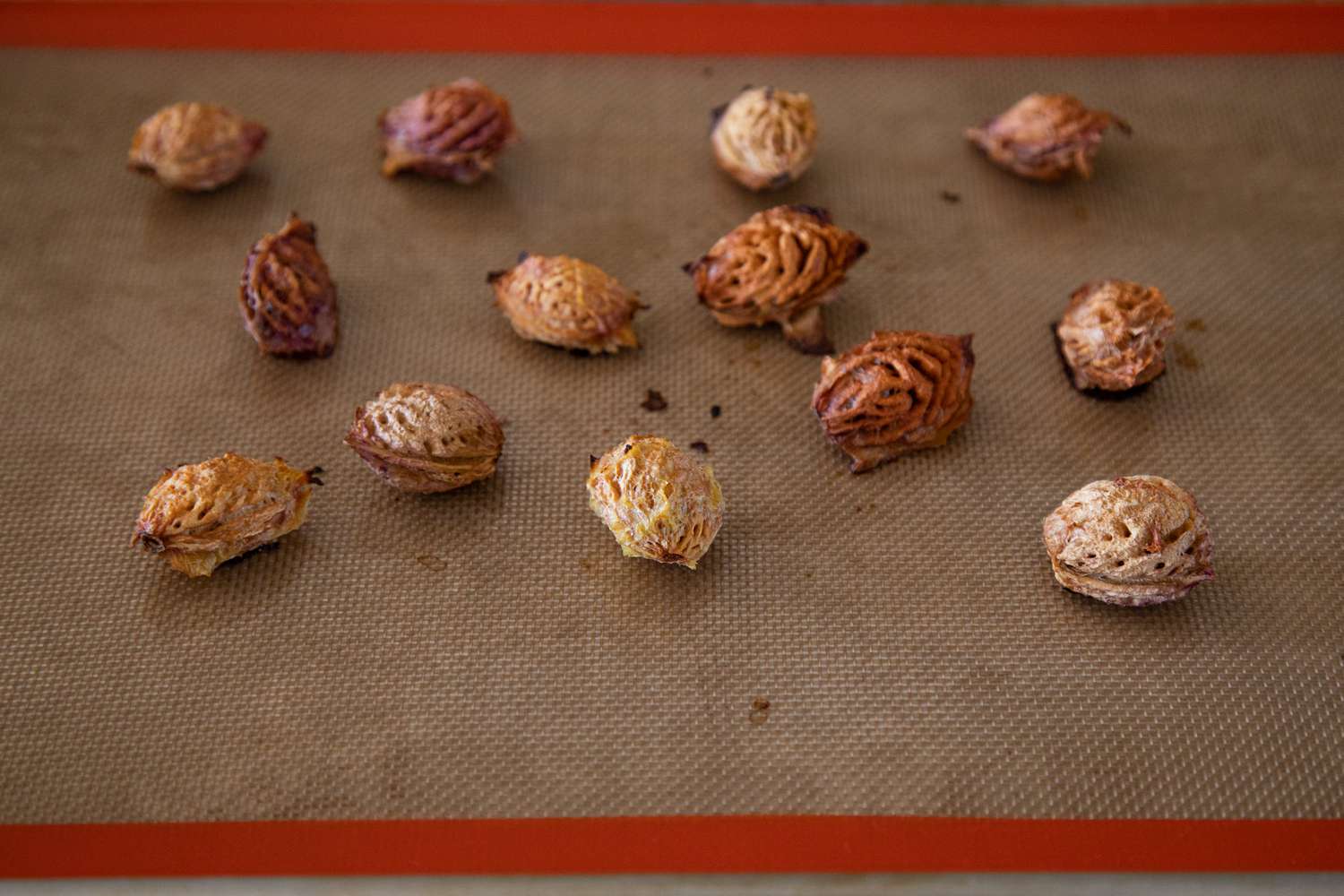 Stone fruit pits on silpat ready to roast for stone fruit pit liqueur