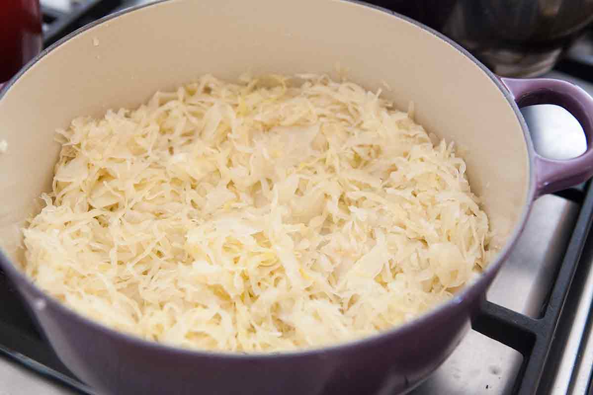 layer sauerkraut in a pot for stuffed cabbage rolls