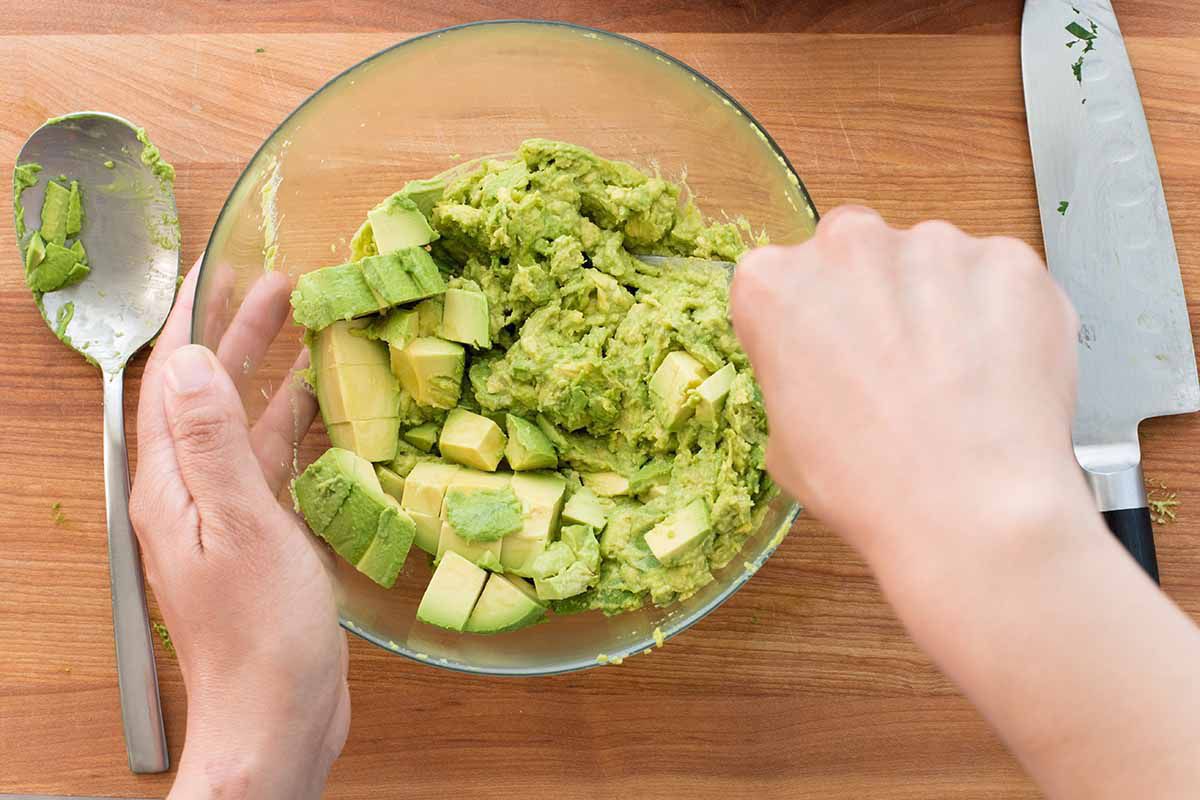 Chipotle Mexican Grill Guacamole - avocados being mashed in a bowl