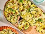 A prepared summer squash salad garnished with herbs and nuts