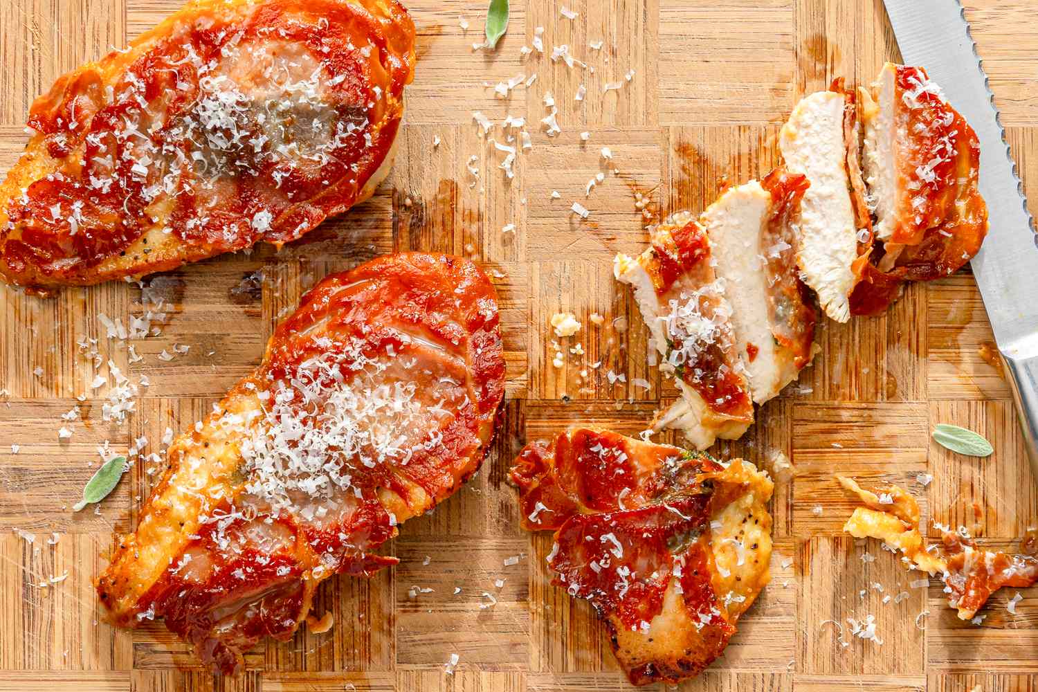 Chicken saltimbocca on a wooden board sliced and topped with grated cheese