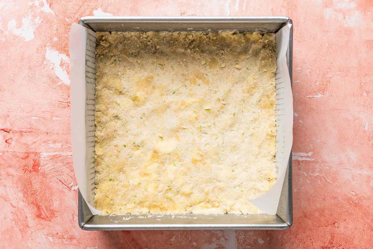 shortbread cookie dough firmly patted into the baking pan for raspberry lime rickey bars recipe