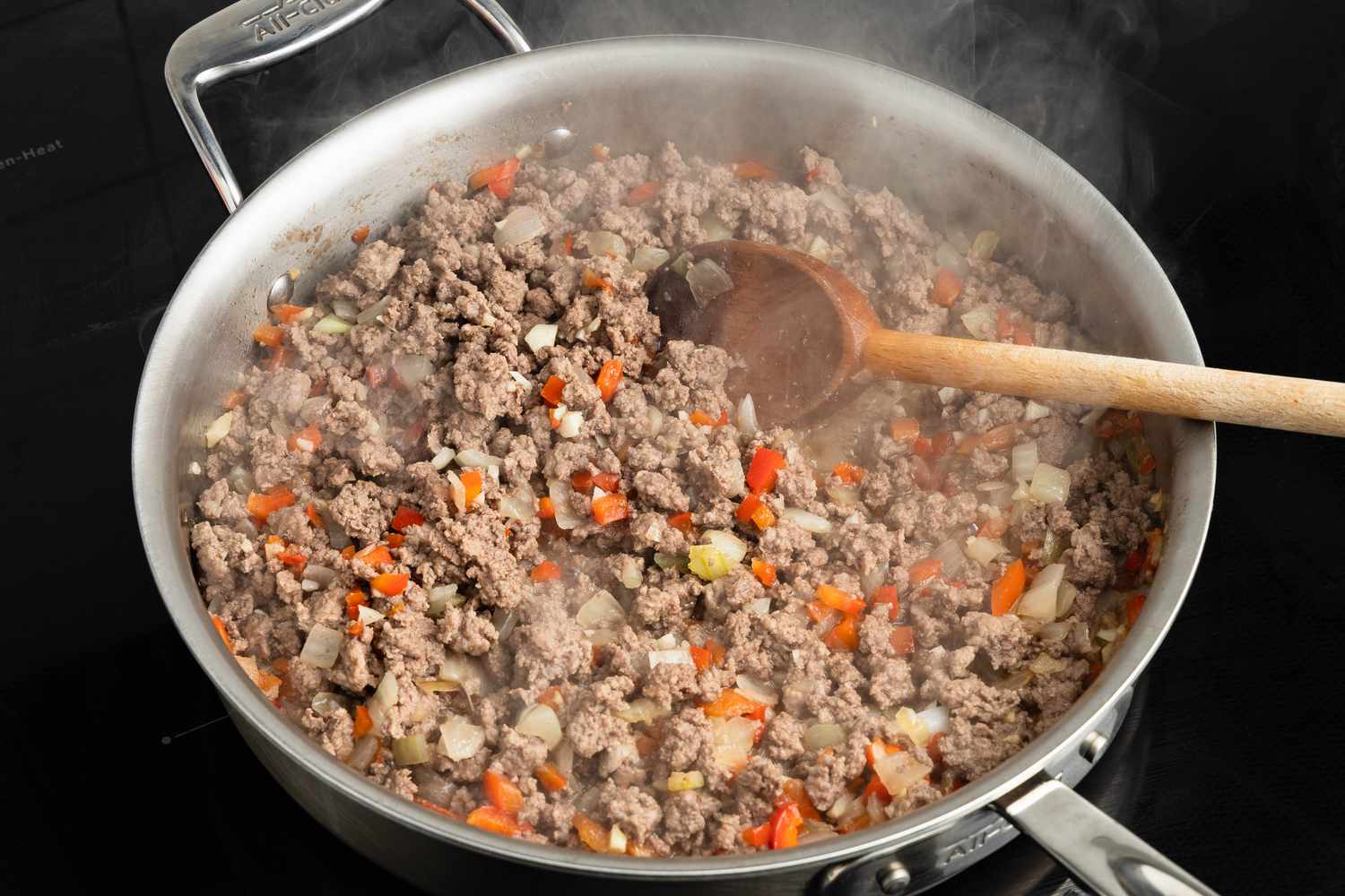 Beef added to skillet on the stove and cooking with the vegetables for Johnny Marzetti casserole recipe