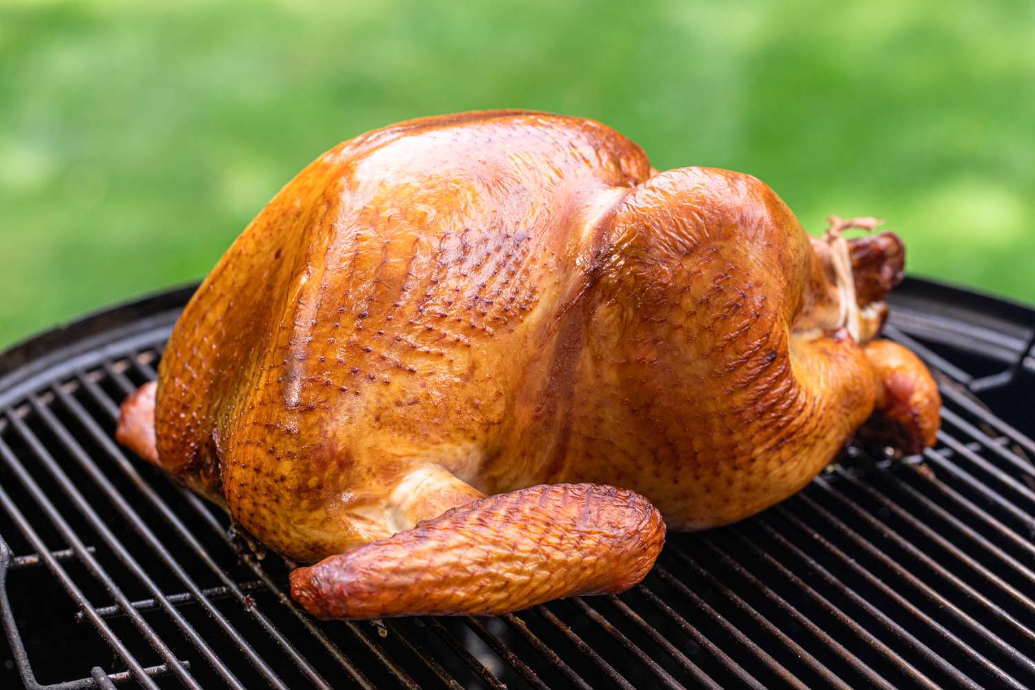 Pecan wood smoked turkey on a grill.