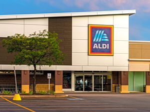 Front exterior of an Aldi supermarket with a tree in the foreground