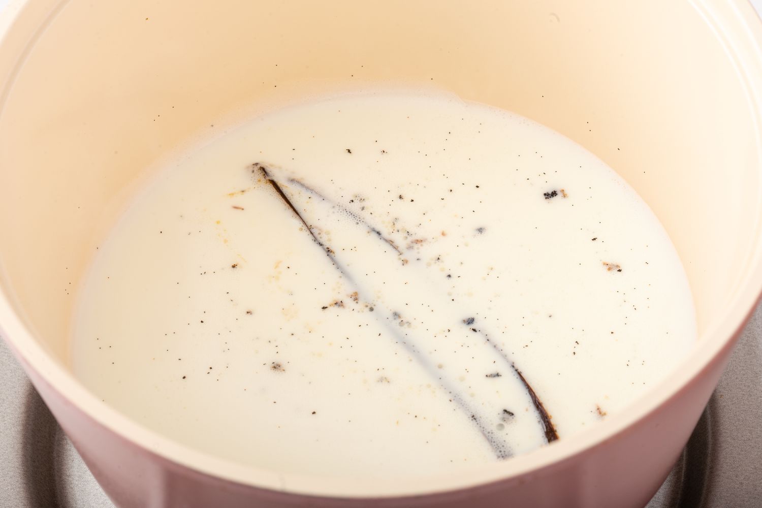 Steeping vanilla bean in cream for the best vanilla cupcake recipe.