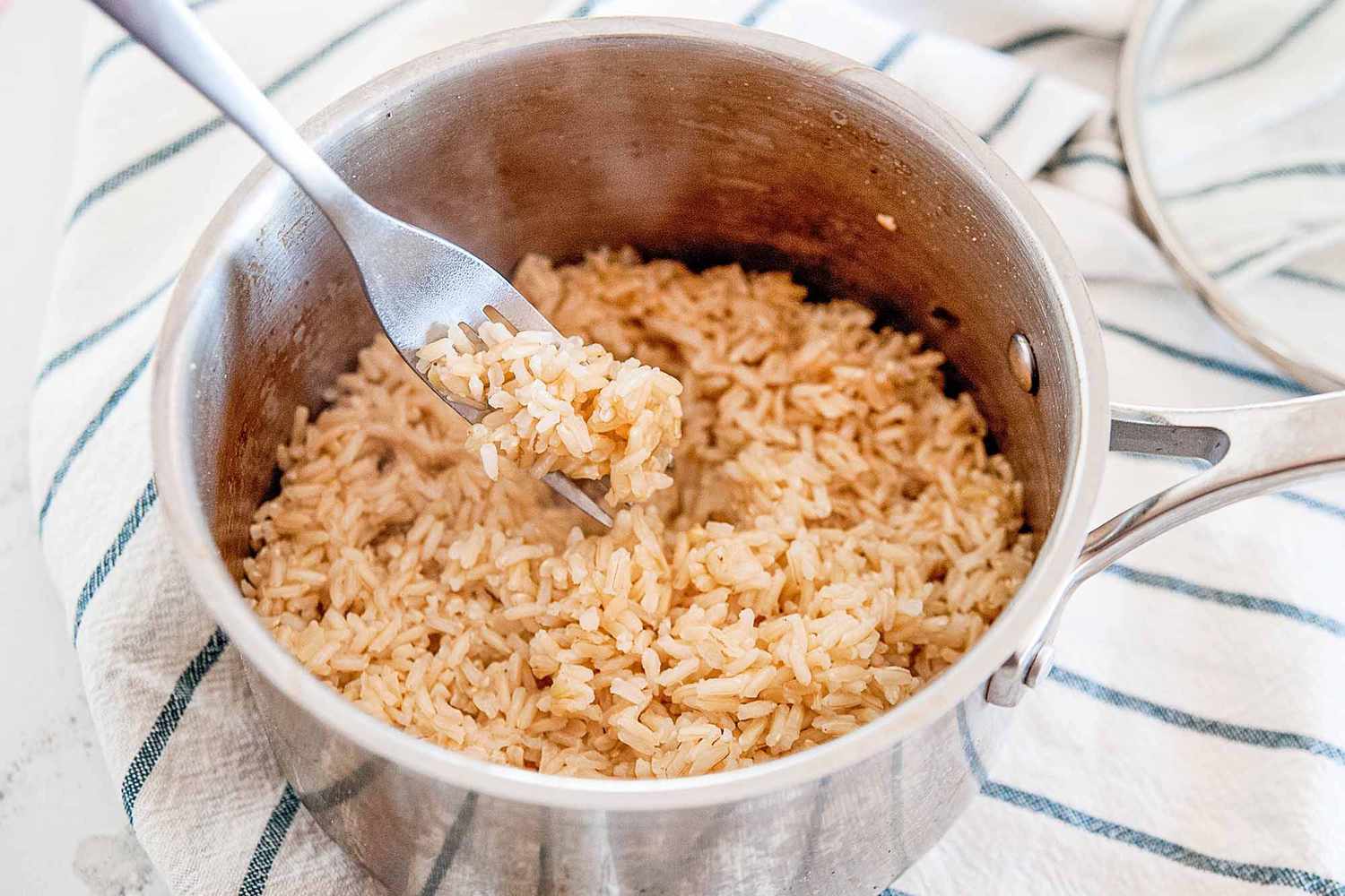 A pot with fork fluffing long grain brown rice