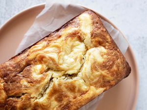 Overhead view of a loaf of cream cheese filled banana bread on a plate.