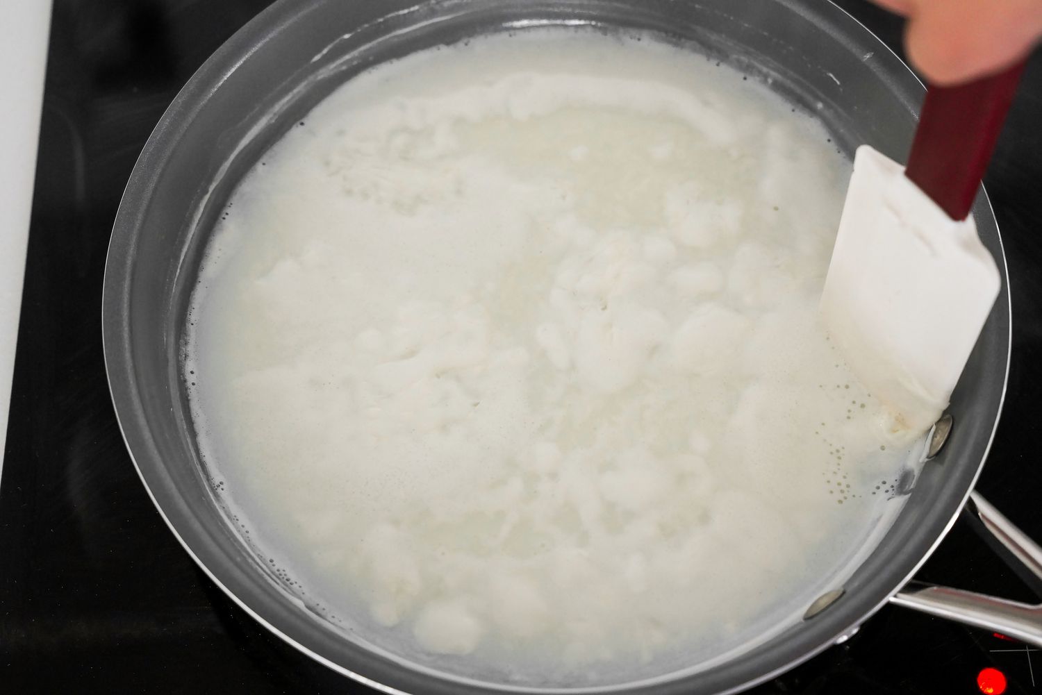 Spatula Used Stir Condensed Milk Recipe in Pan on the Stove 