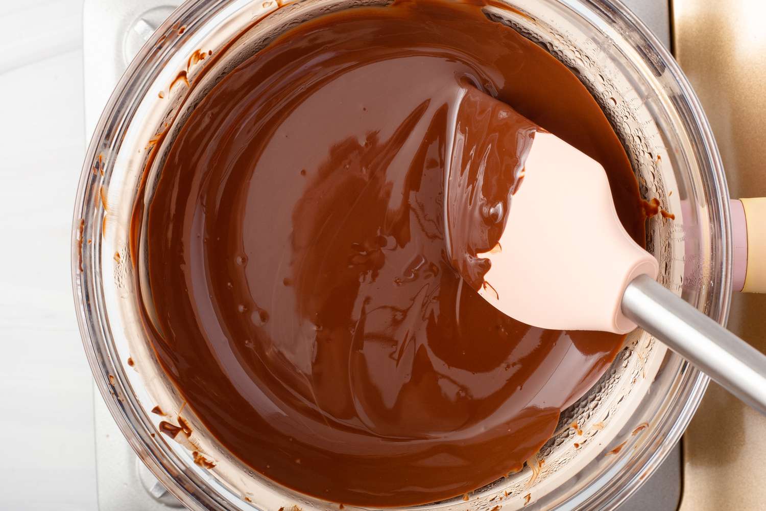 Overhead view of a glass bowl of melted chocolate.