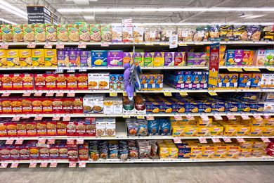 Shelves stocked with various brands of boxed macaroni and cheese in a grocery store aisle
