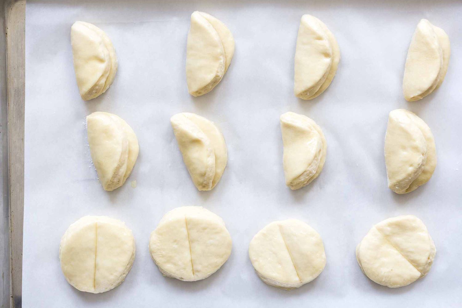Original Parker House Rolls Recipe parker house rolls unbaked folded in half on a sheet