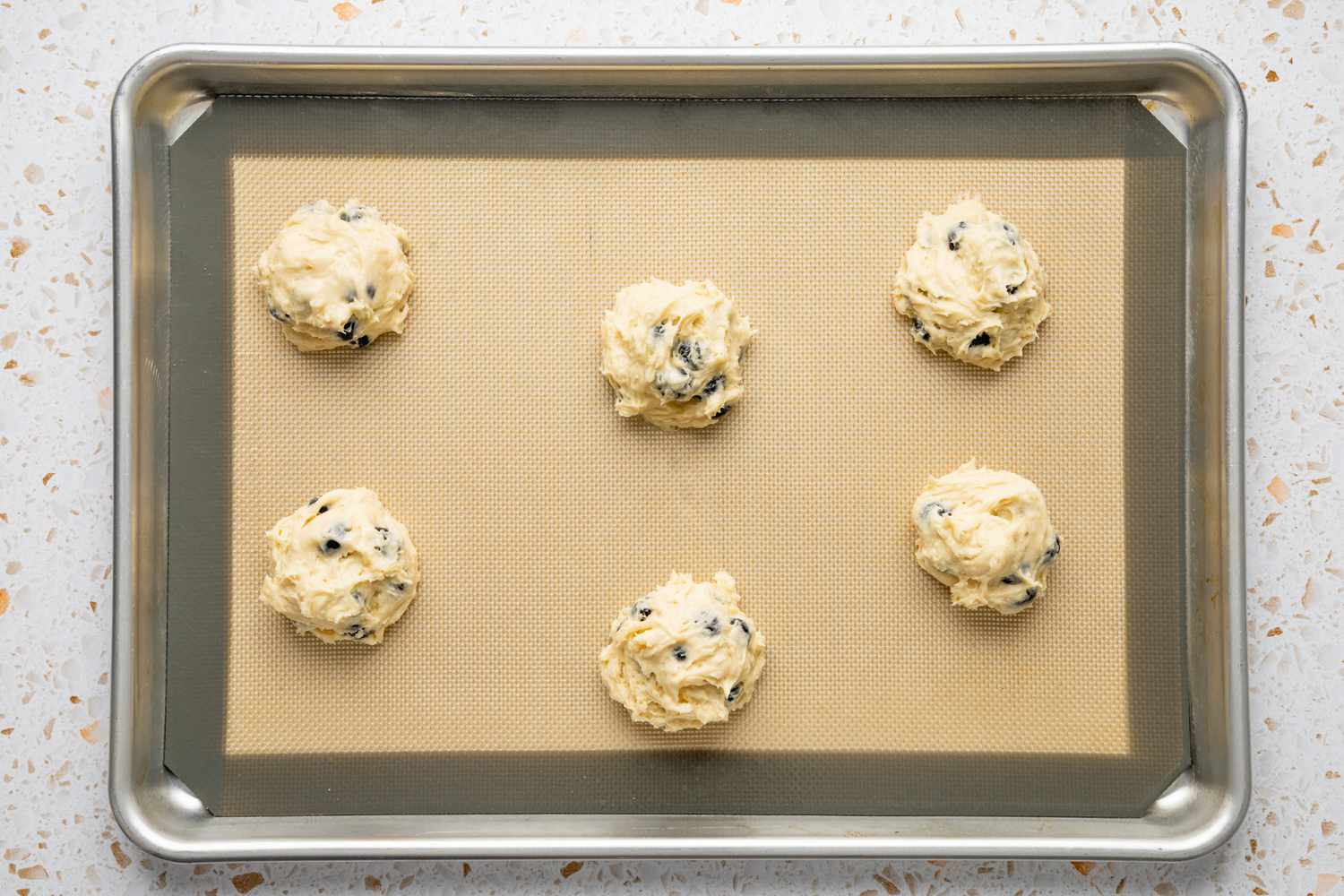 Blueberry Muffin Top Batter Portioned Out on a Silpat Lined Baking Pan