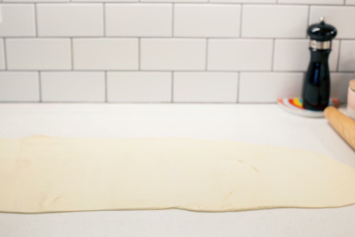 Side view of Utah's Famous Lion House Roll dough rolled out on a countertop.