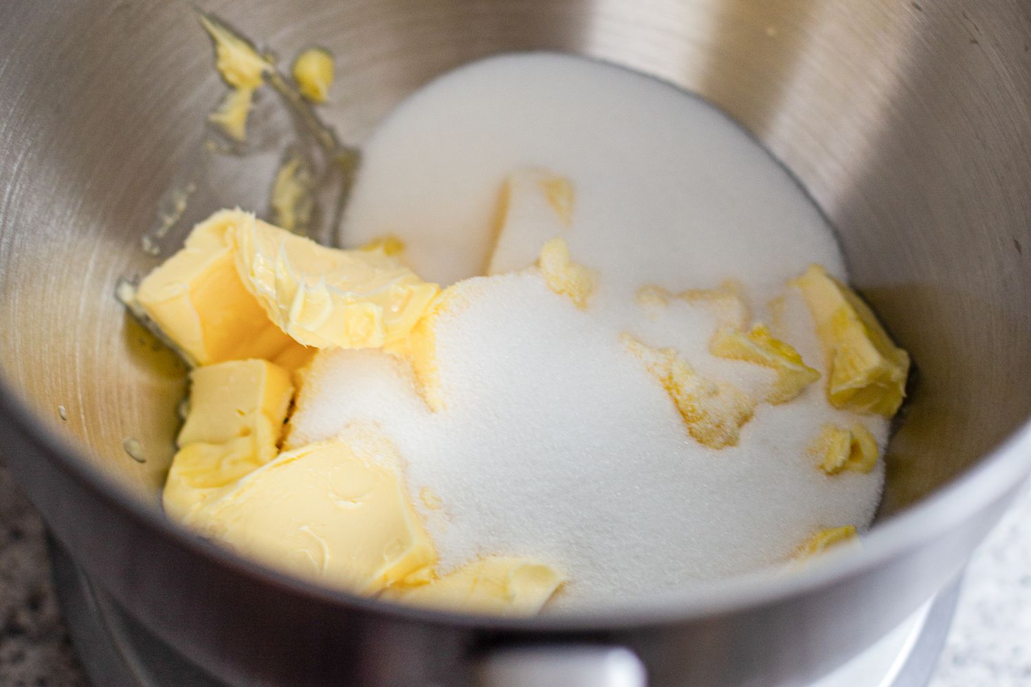 Butter and sugar in a metal bowl to make marzipan stamped cookies 