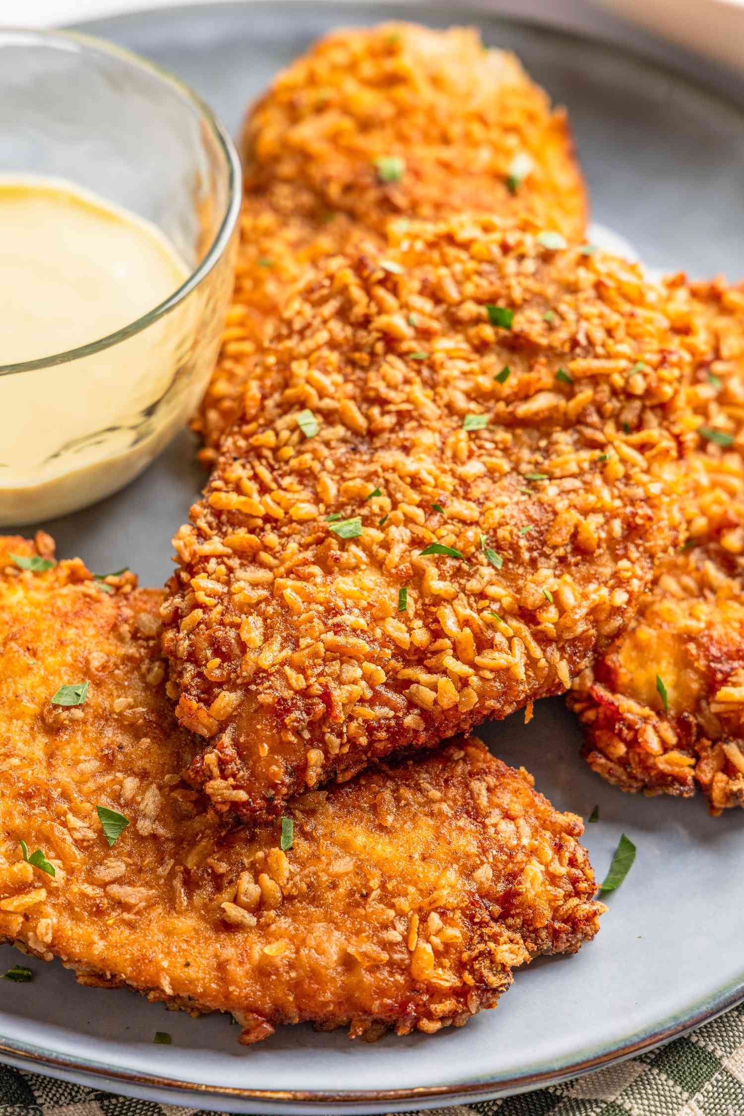 close-up: pretzel chicken on a plate with a bowl of sweet dijon mayo 