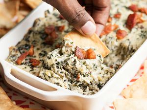 Easy Spinach Artichoke Dip with Bacon in a white casserole dish