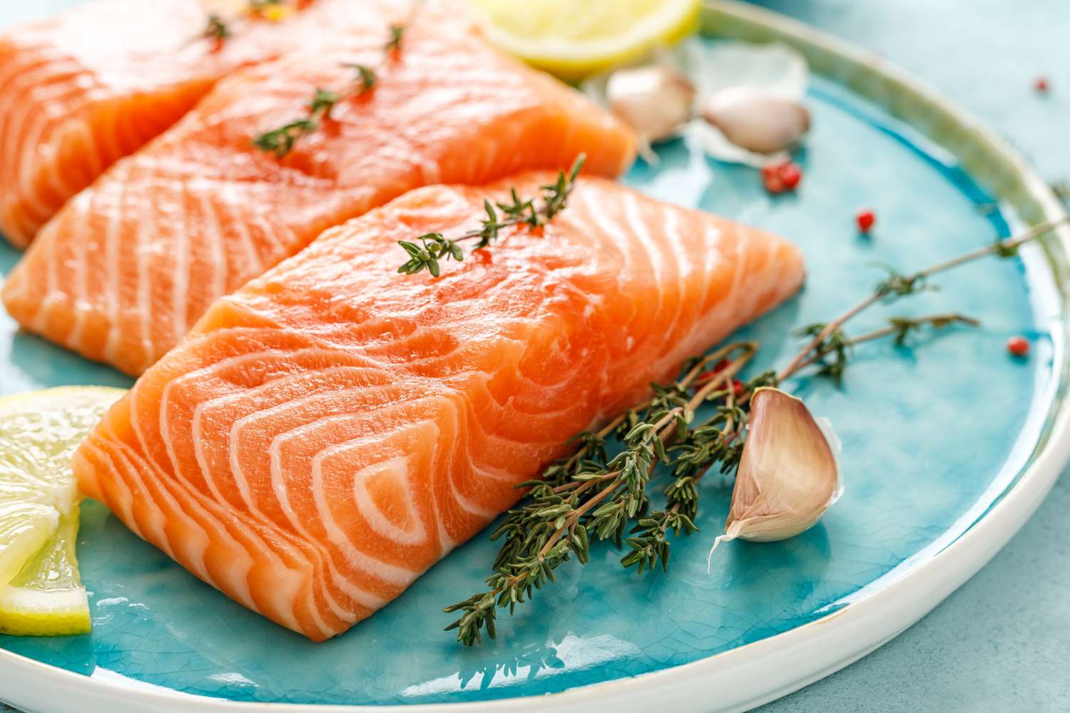Raw salmon fillets on a blue plate