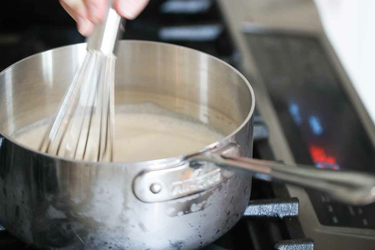 Warming and whisking cream in a pot