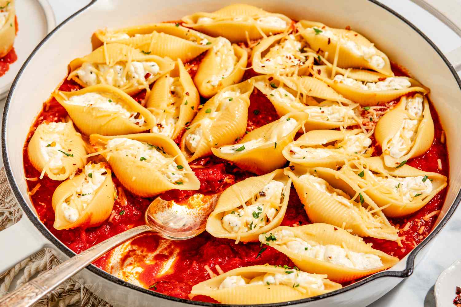 Stovetop Stuffed Shells in a large pan with a large serving spoon