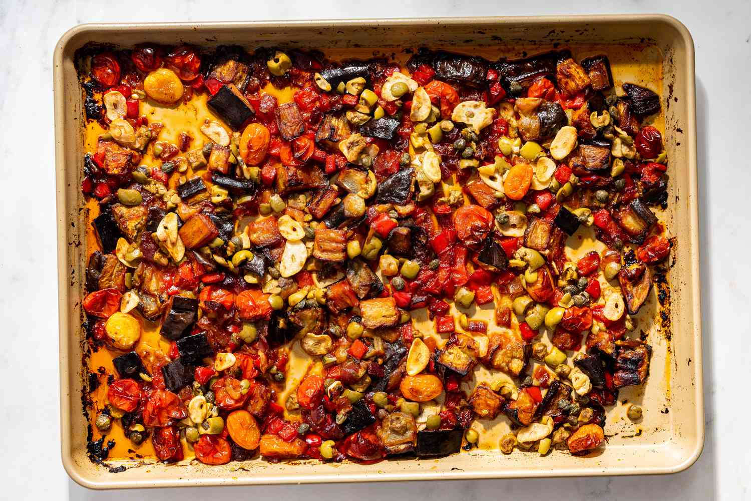 roasted vegetables after garlic, capers, and olives were added to the sheet pan for caponata pasta recipe