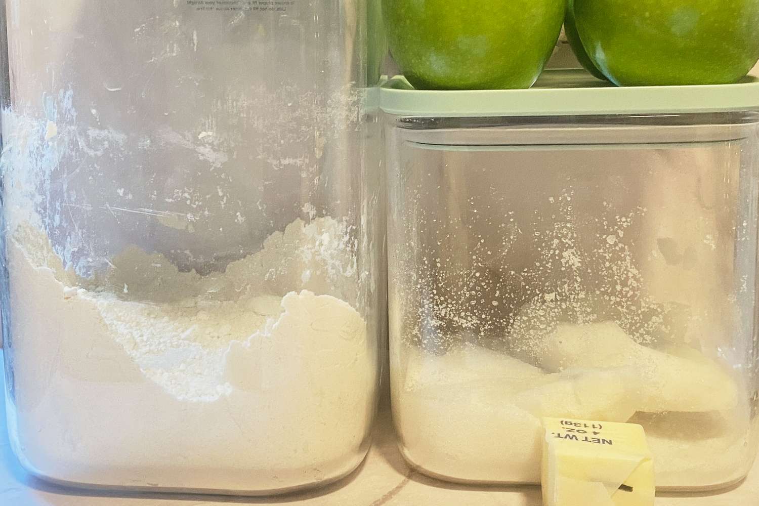 Ingredients for baking including flour sugar and apples neatly arranged in containers