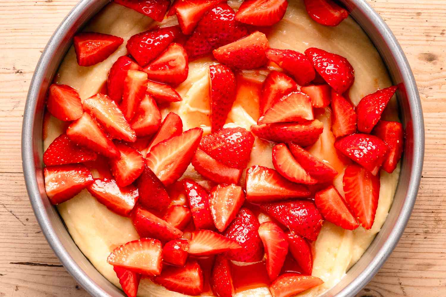 strawberries on top of cake batter (uncooked) for strawberry spoon cake recipe