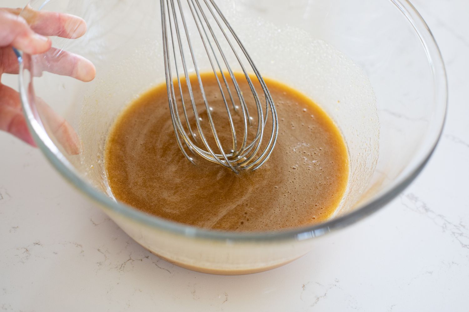 Wet Ingredients for Zucchini Carrot Bread in a Bowl with a Whisk 