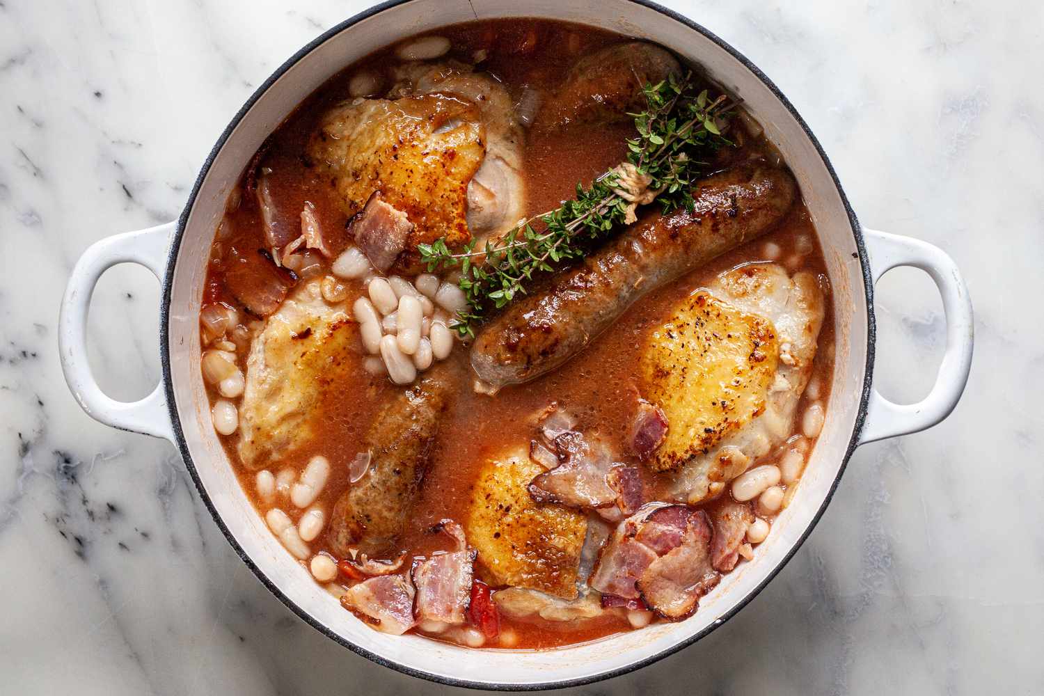 Dutch oven with all of the cassoulet ingredients pre-cook.