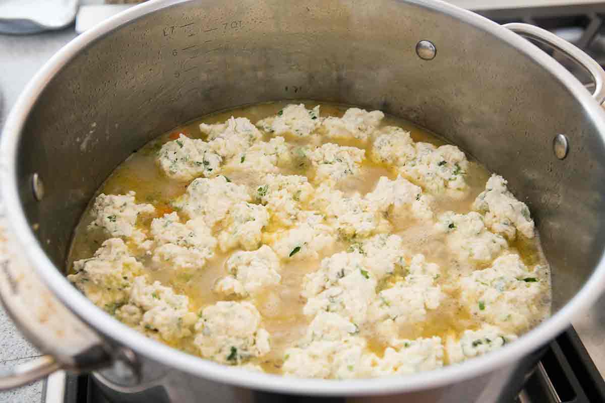 Stock pot with chicken dumplings floating on top.
