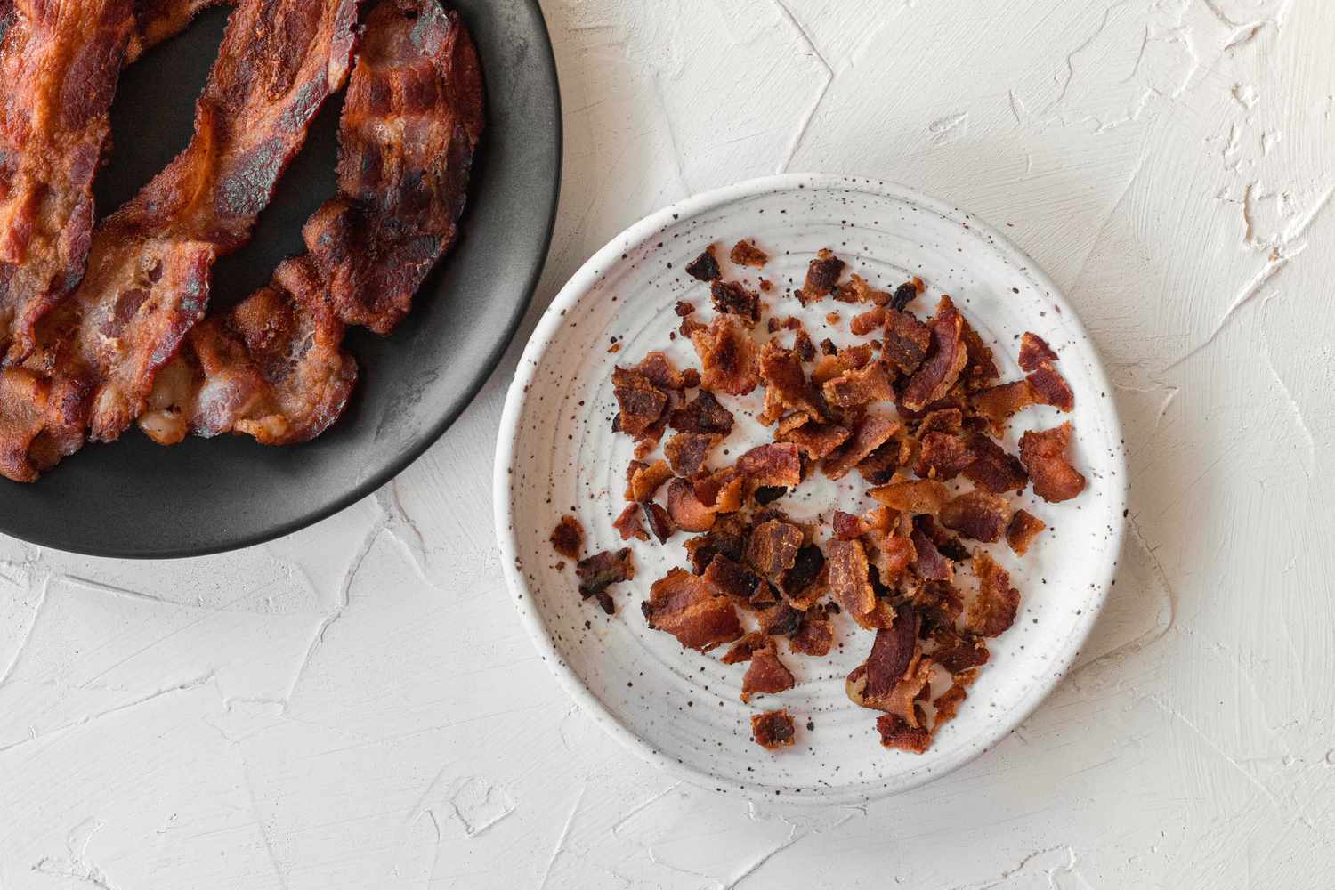 Bacon cooked and chopped into pieces on a plate for a potato skins recipe.