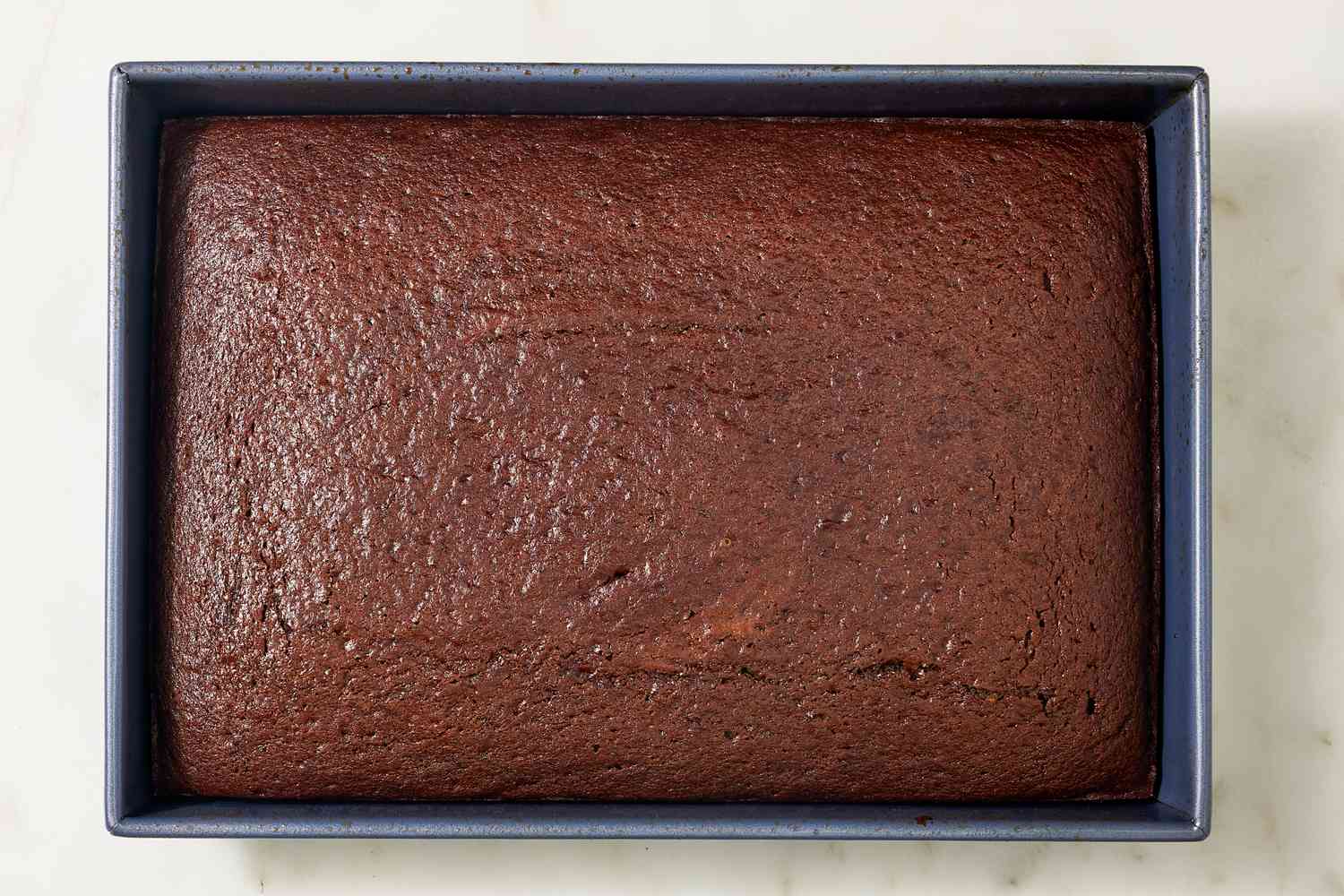 Overhead view of Coca Cola Cake recipe batter after baking in a metal baking pan