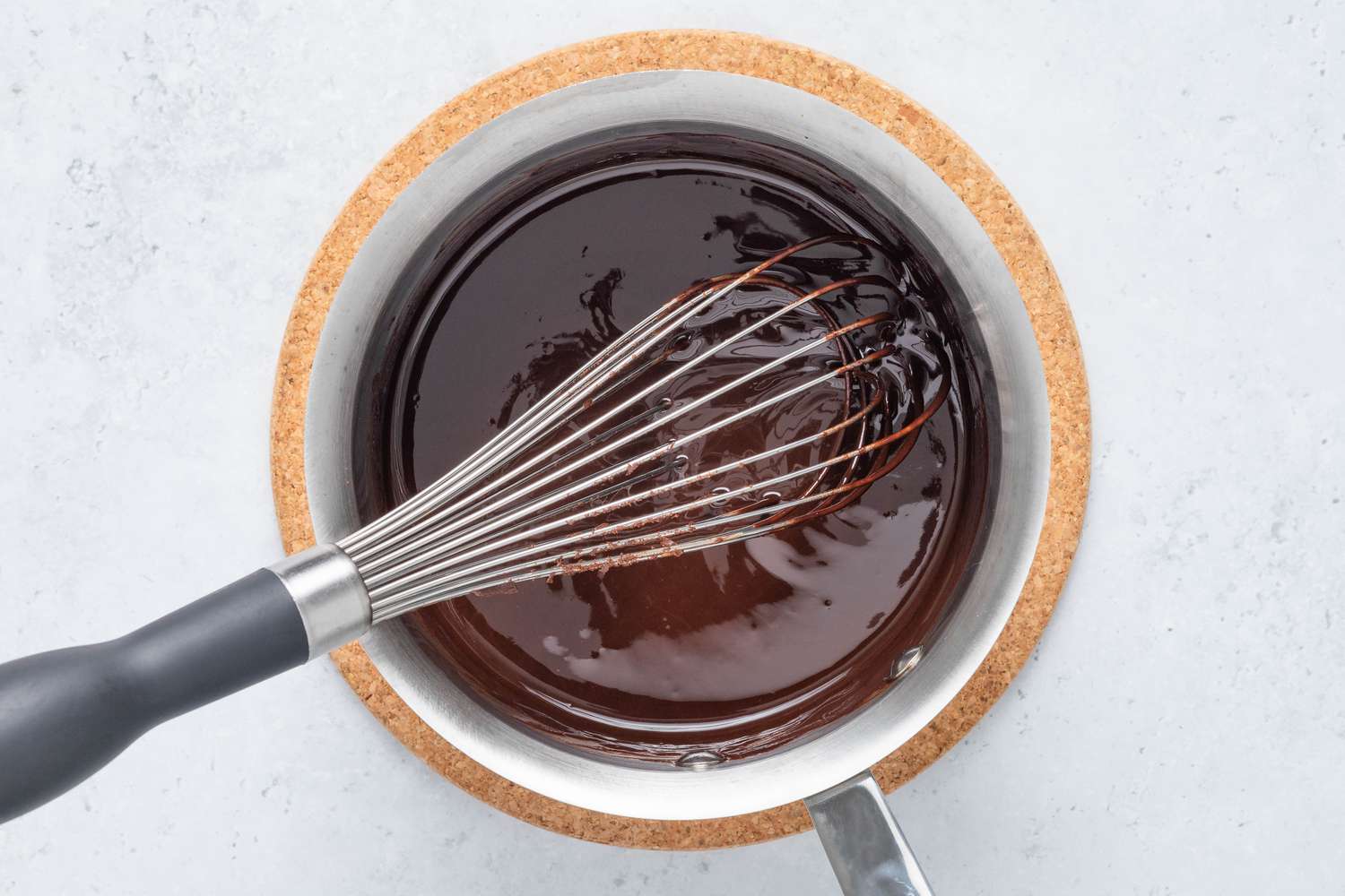 Chocolate pieces whisked into the melted butter and cocoa mixture in the pot for homemade Cosmic Brownie recipe