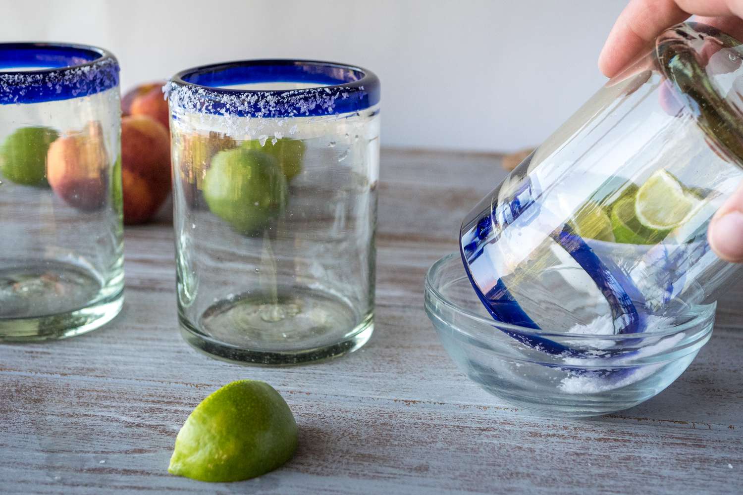 Adding salt to the rim of a glass to make margaritas.