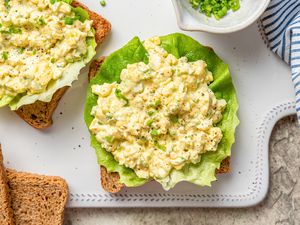 egg salad sandwich being made on a cutting board