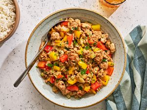 A serving bowl of cooked ground turkey and peppers with white rice on the side