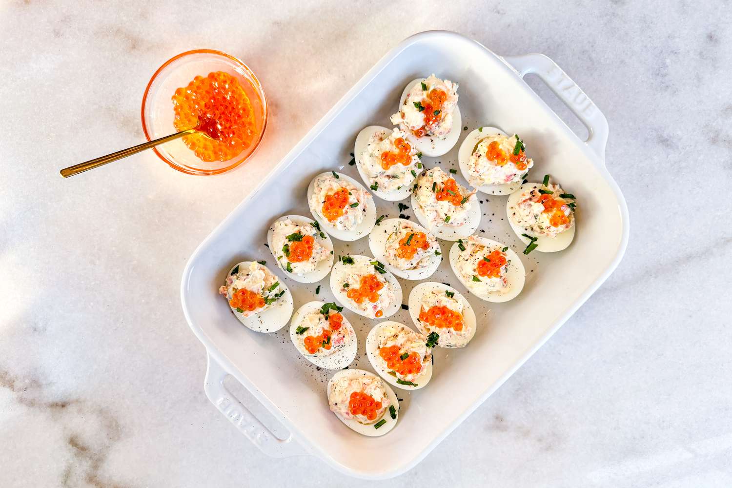 Overhead shot of a tray with devlied eggs topped with salmon roe