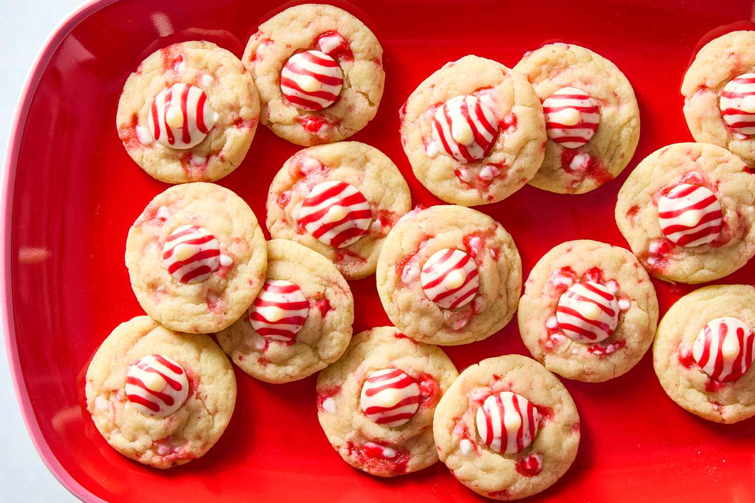 Overhead shot of peppermint sugar cookies on a red serving dish