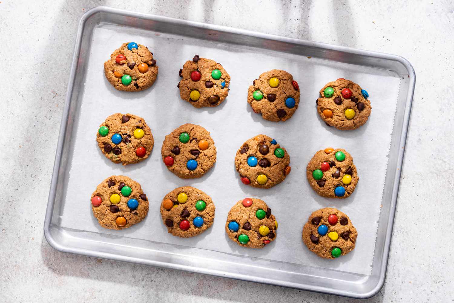 Baked monster cookies on the parchment paper lined baking sheet