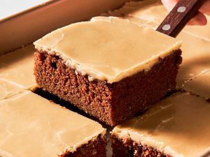 Dr. Pepper cake cut into squares with one square lifted using a spatula