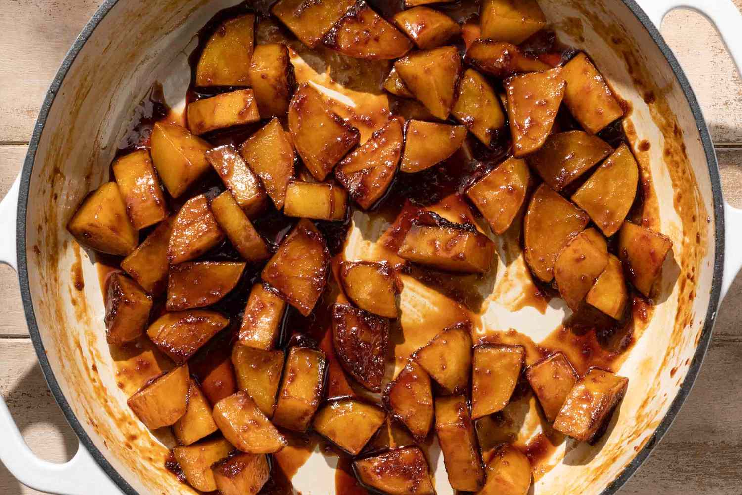 Overhead view of potato slices being glazed with the sauce for Gamja Jorim (Korean Braised Potatoes) recipe