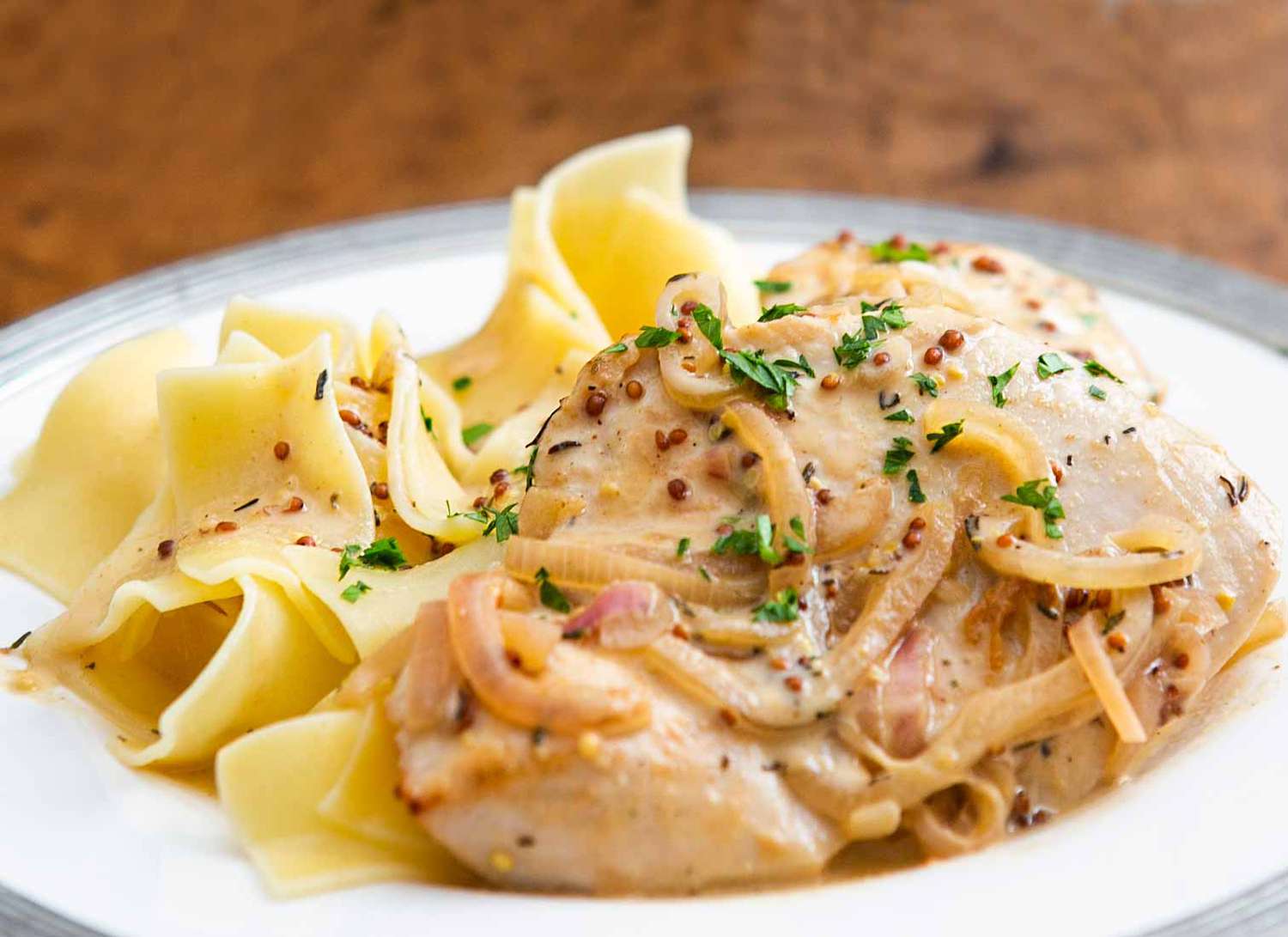 A serving of creamy dijon chicken over noodles in a bowl