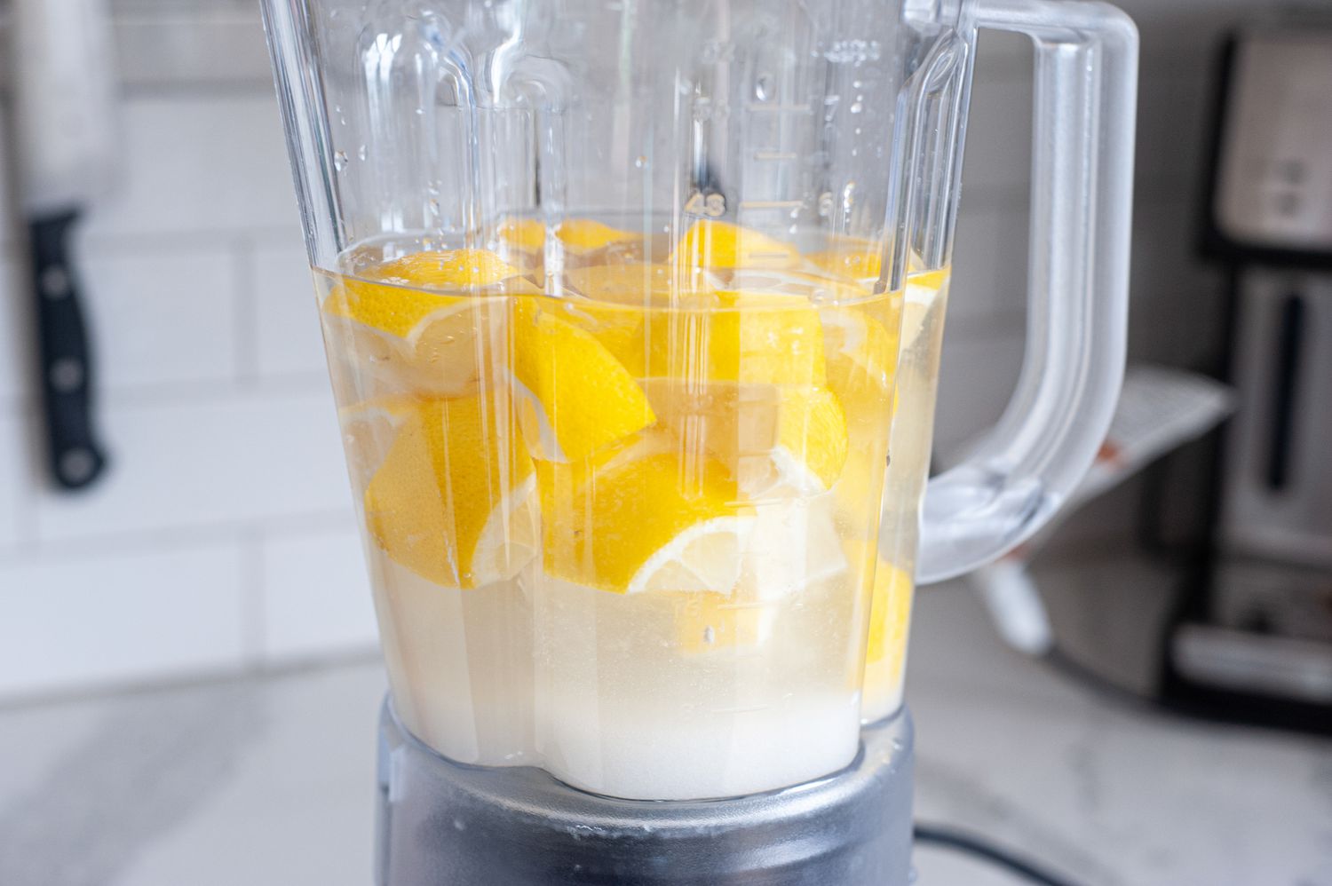 A blender with ingredients to make blended lemonade.