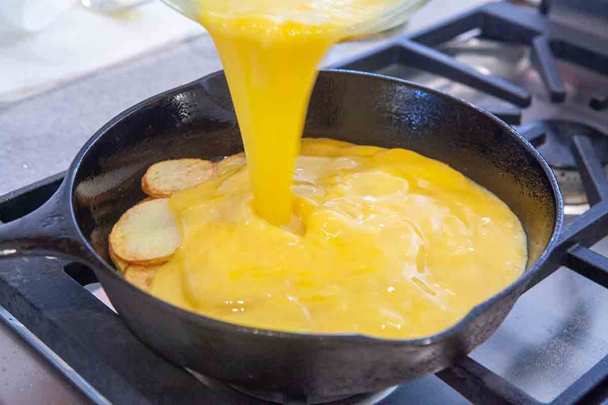 pour egg mixture over potatoes for spanish tortilla