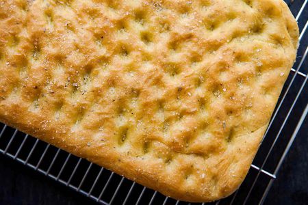 Easy focaccia bread with rosemary baked and cooling on a cooling rack