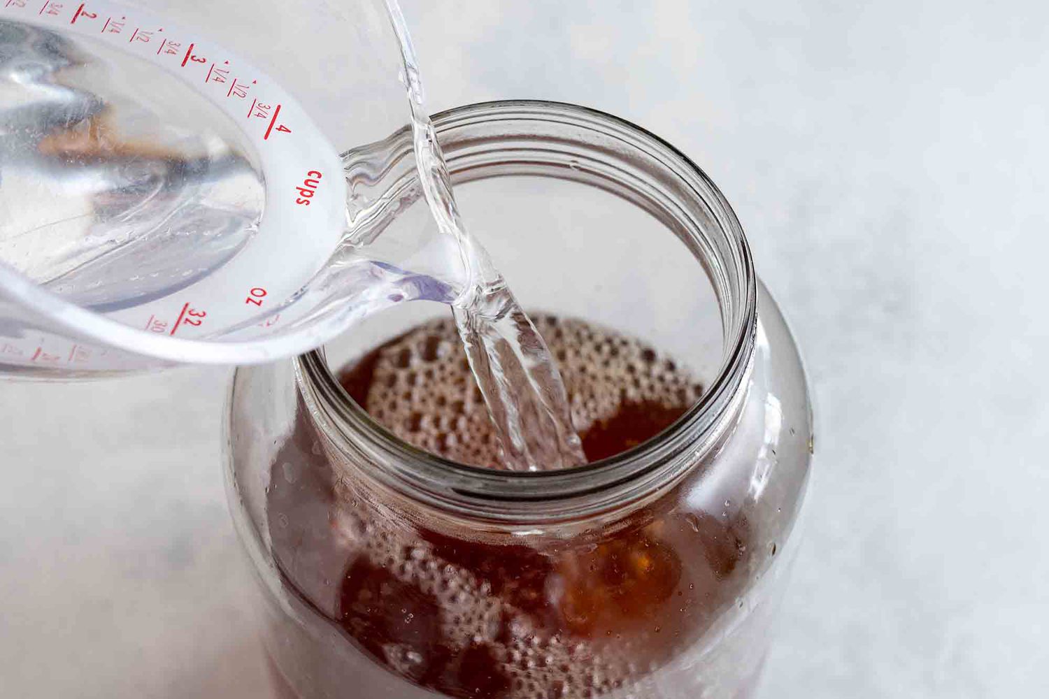 Add water for homemade kombucha to top off the sweet tea in the jar