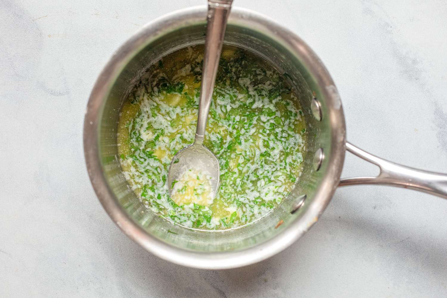 Butter sauce in a pan to spoon over one pan roasted garlic butter shrimp and asparagus.