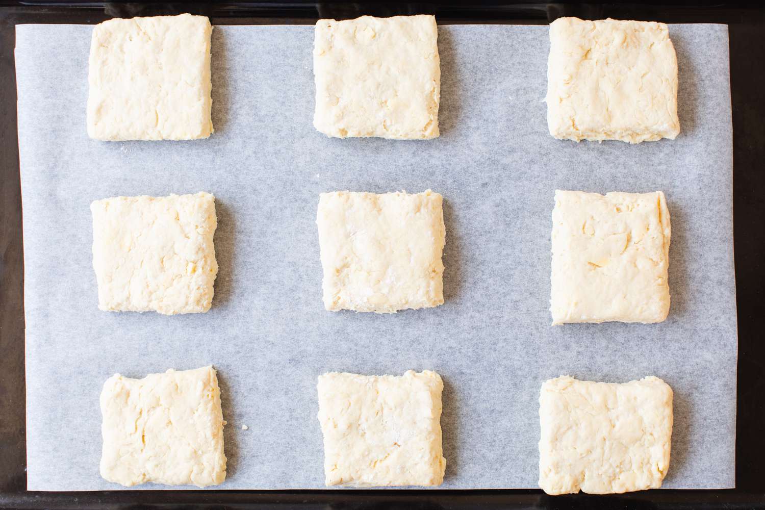 Chilled Biscuit Dough Cut into Size Biscuit Pieces on the Baking Sheet