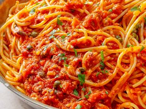 A pasta dish with sardine and tomato sauce garnished with herbs