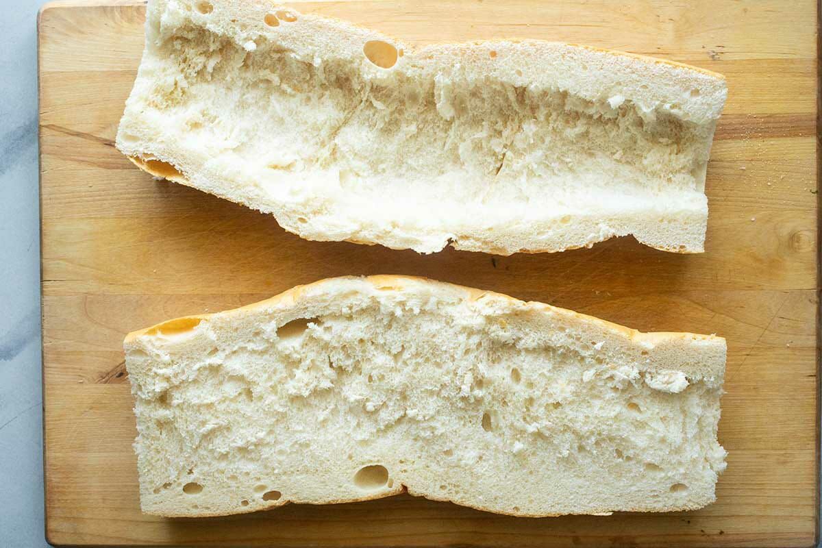 Easy italian sub sandwich loaf cut in half horizontally and with the top scooped out.